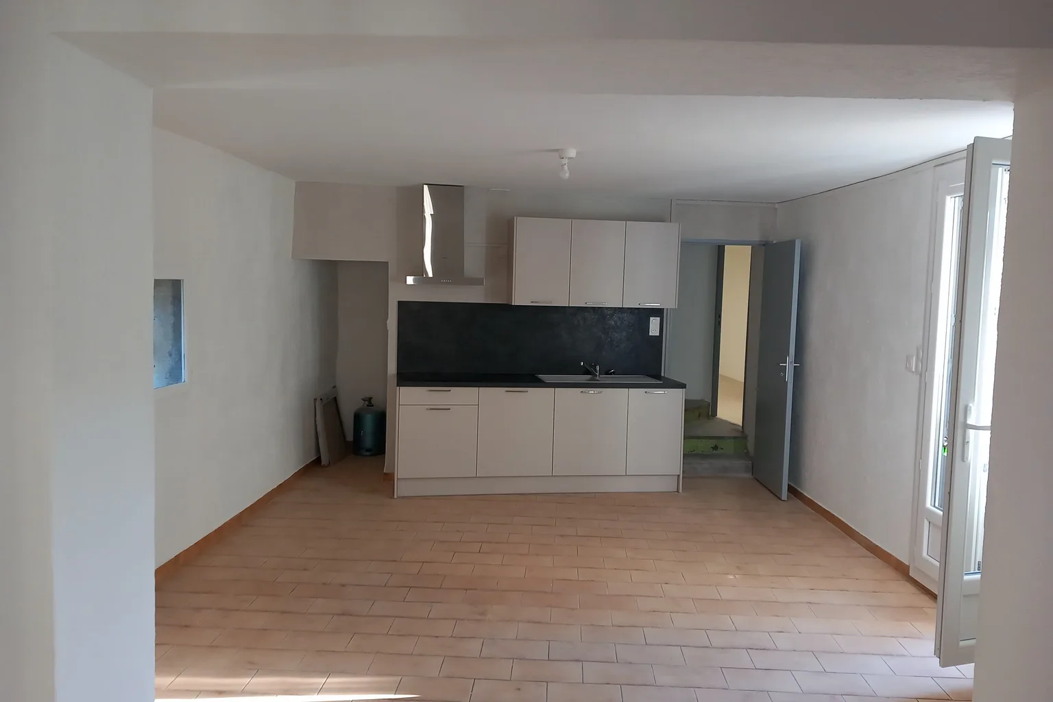 Plombier professionnel réparant une canalisation sous un lavabo dans une salle de bain sombre, avec des outils spécialisés, intervention en urgence 24h/24